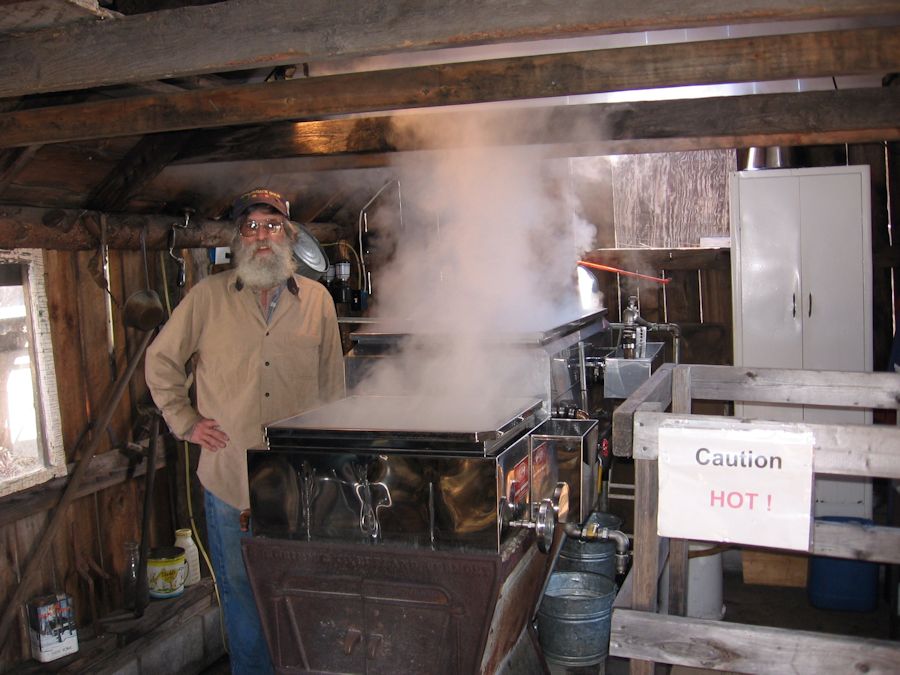 Man boiling sap in his evaporator to makle maple syrup