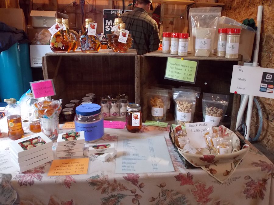 Table displaying maple products: sugar, cream, cotton candy, peanuts, popcorn, jelly, coffee