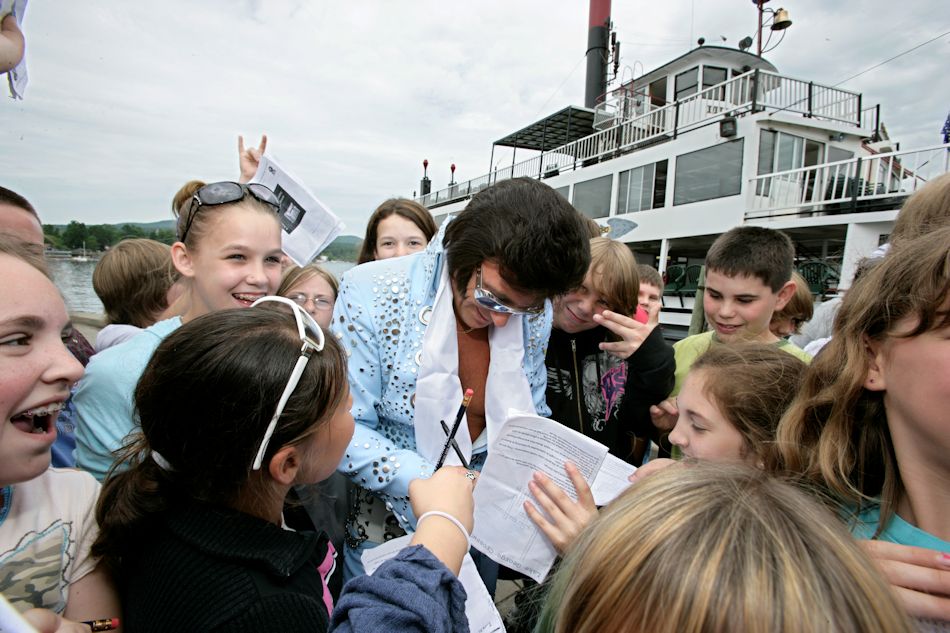 Elvis impersonater signs autographs for group of children at Lake George Village, in the southern Adirondacks of New York 