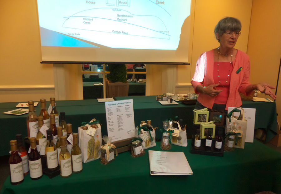 Docent at table with samples of items sold from Herb and Vineger Workshop at Filoli