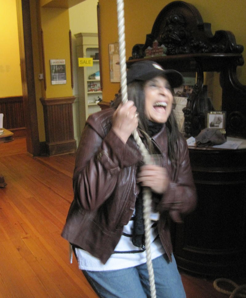 Woman ringing bell at former schoolhouse in Madison