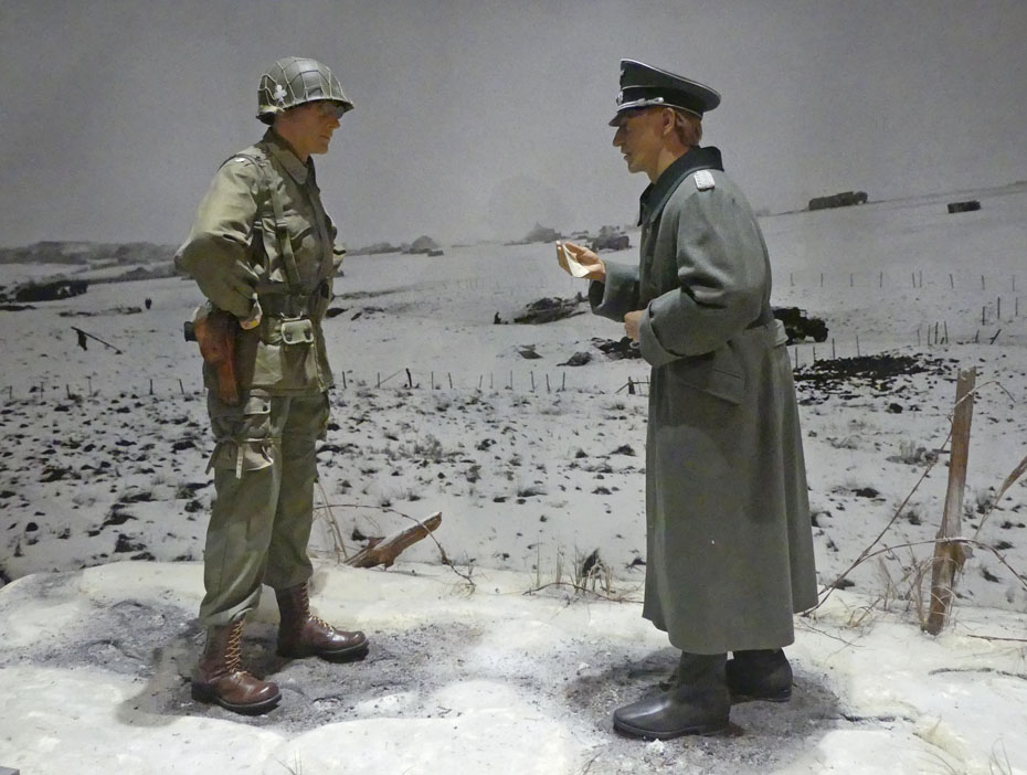 exhibit showing American soldier facing German soldier in snowey field 