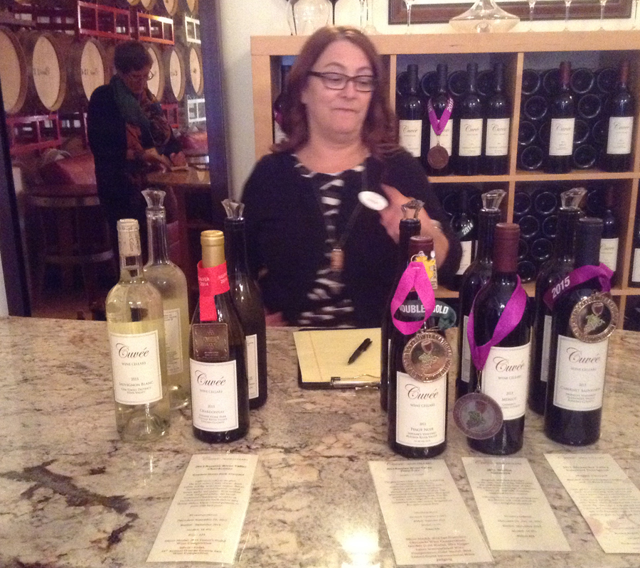 woman stanidnb behind table with wine from Cuvee Wine Cellar