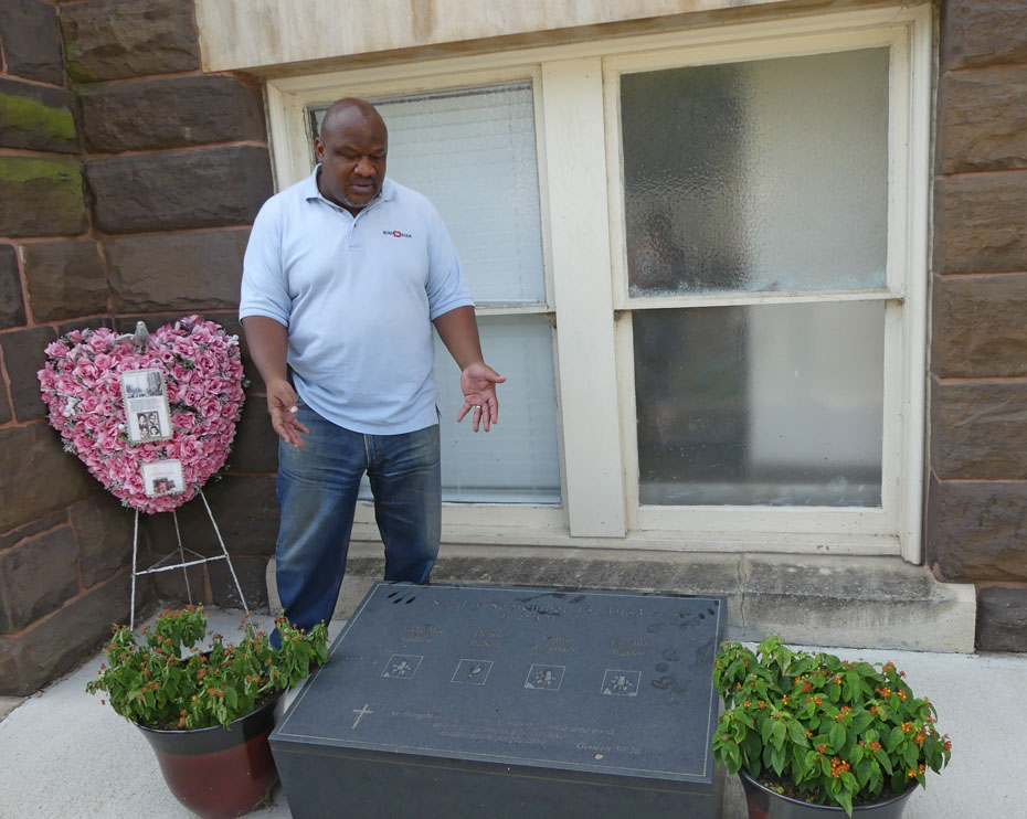 Tour guide displaying plaque commemorating the four young girls murdered in 16th st Baptist Church bombing