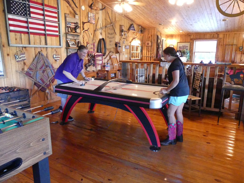 Man and girl playing a table game at French Broad Outpost Dude Ranch in Eastern Tennessee