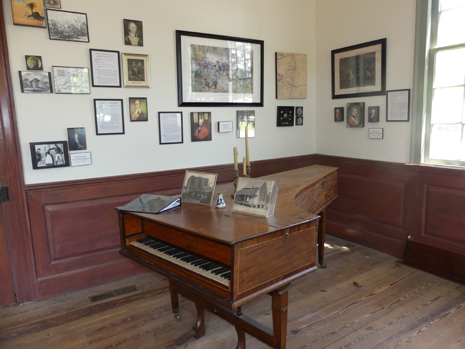 Interior of John Craven house showing piano and pictures on wall at Historic Camden