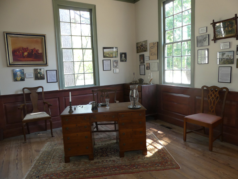 Interior of John Craven house showing desk and pictures on wall at Historic Camden