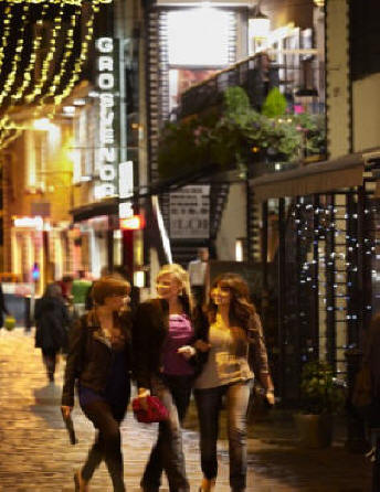 Three women walking on Ashton Lane in Glascow, Scotland