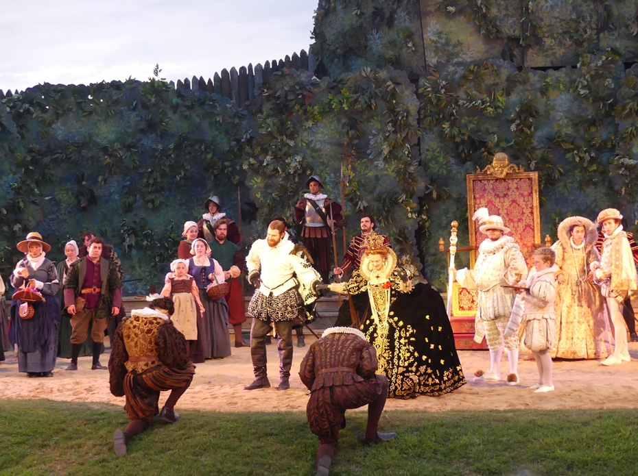 Sir Waltyer Raleigh presents tow native american warriers dressedin English costume to Queen Elizabeth as court and villagers look on