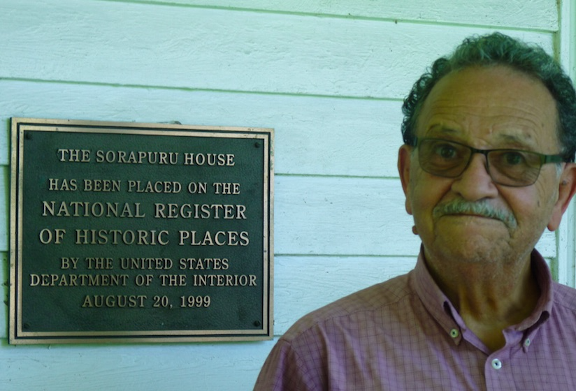 man stanidng nest to sign depicting National Historic places designation at Sorapuru House