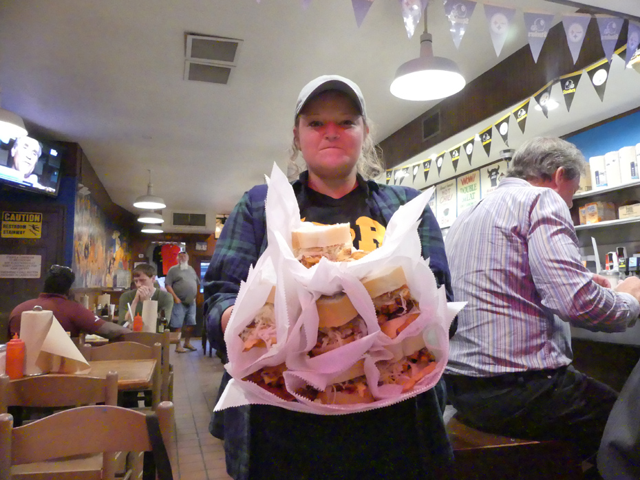 Waitress in Primanti Brothers carrying seven sandwiches
