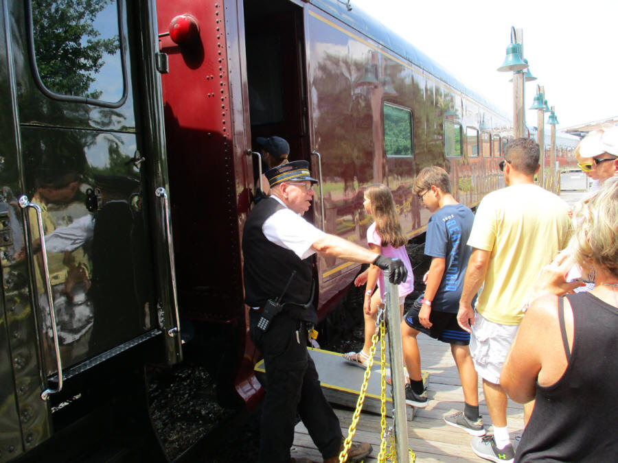 passengers boarding trail wiht conductor at door
