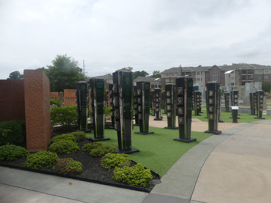 Black glass columns in front of brick wall